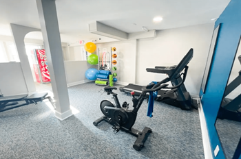 The Canvas gym with a rowing machine, a stationary bike, and a treadmill.